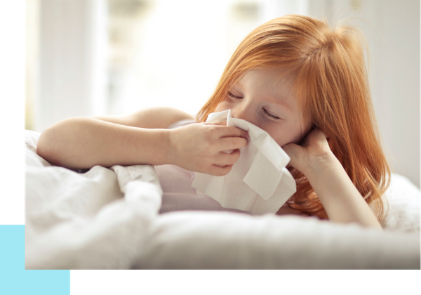 young girl blowing nose
