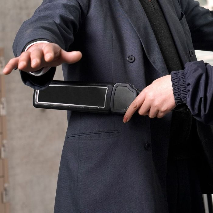 a security guard using a metal detector How Private Security Can Create Safer Work Environments (2).jpg