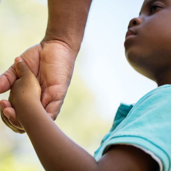 child holding hands with adult