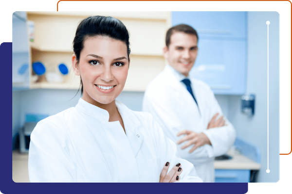 Two smiling healthcare professionals in white lab coats in clinic.
