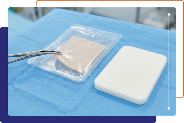 Advanced skin substitute and foam dressing on surgical tray.