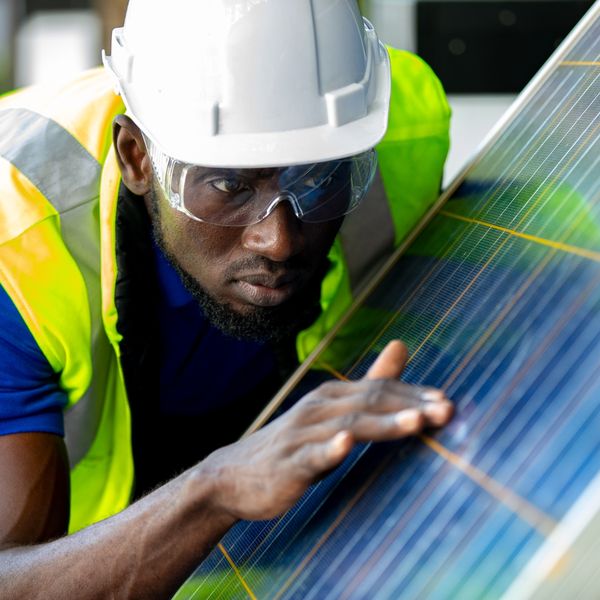 man looking closely at solar panels