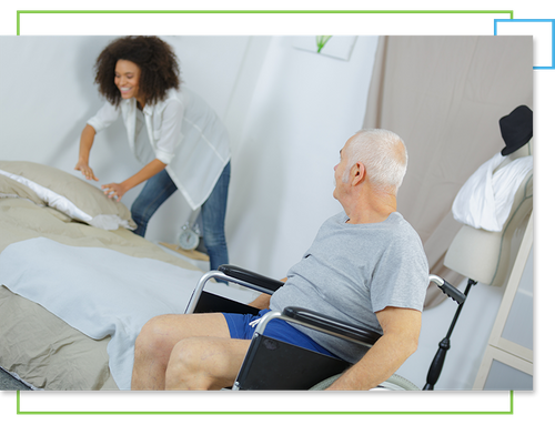 Woman making bed for man in wheelchair