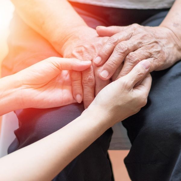 elderly man's hands with caretaker