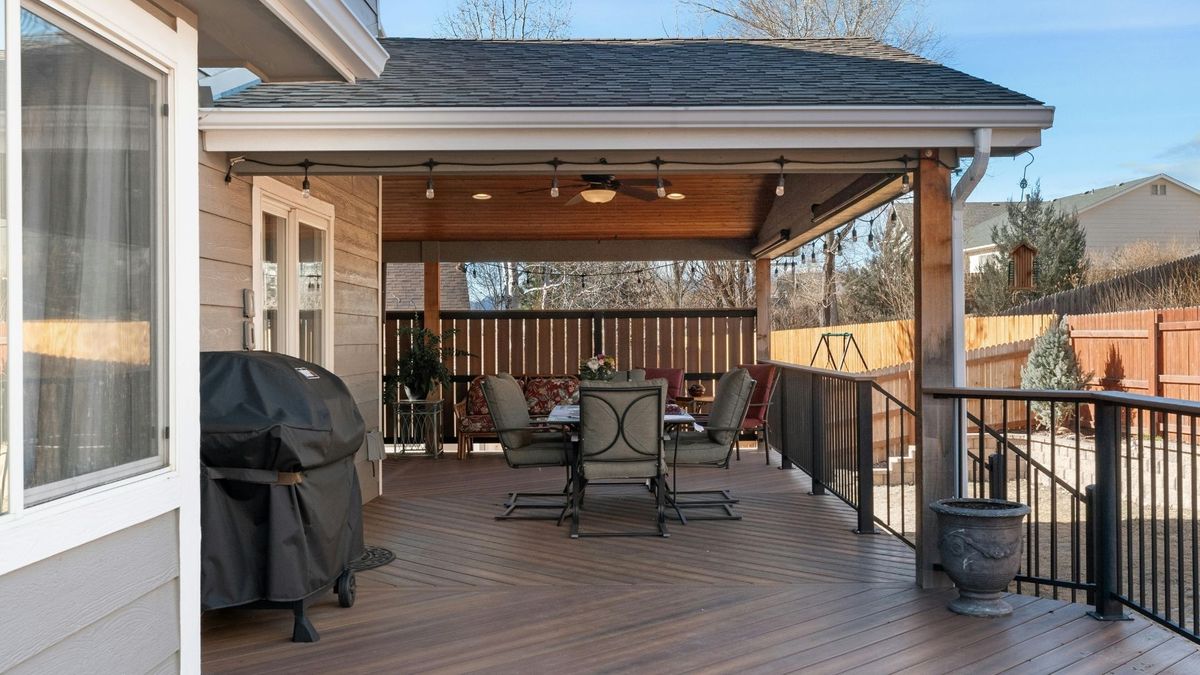 A deck with a shelter and outdoor furniture