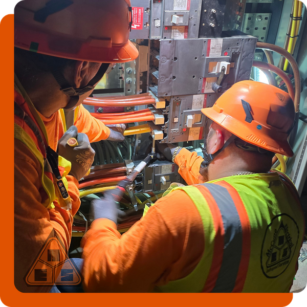 McCune Electric contractors performing emergency commercial electrical work on an industrial panel.