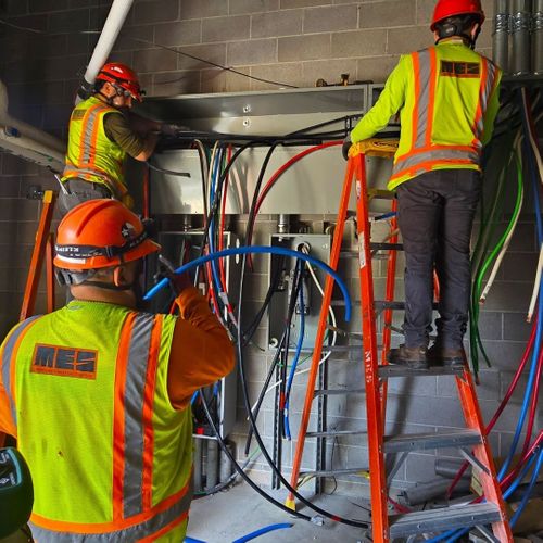 Electricians installing wall conduits and wiring