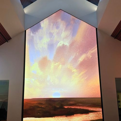 Large display screen showing a colorful sunset sky