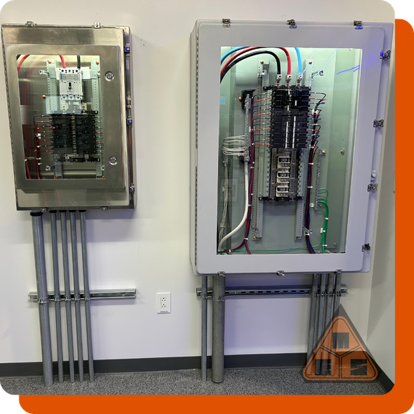 Two meticulously wired electrical panels, one stainless steel and one with a transparent cover, showcasing clean conduit work and professional installation.