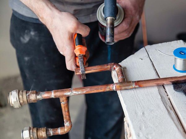 Closeup of a plumber working with copper piping