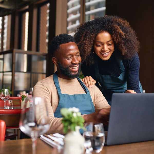 restaurant owners looking at laptop