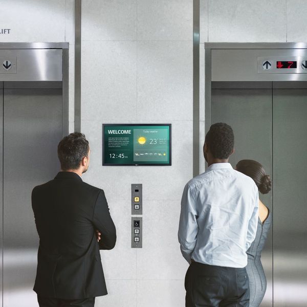 small TV near elevator in hospital or office displaying weather and news