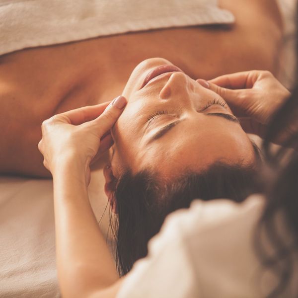 woman getting facial massage at spa