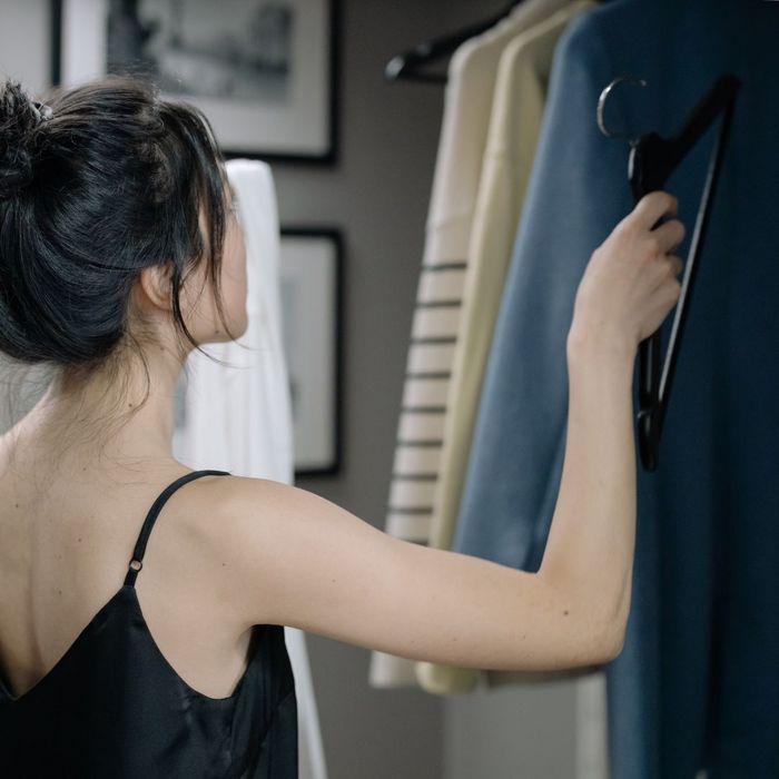 woman looking at clothes in her closet