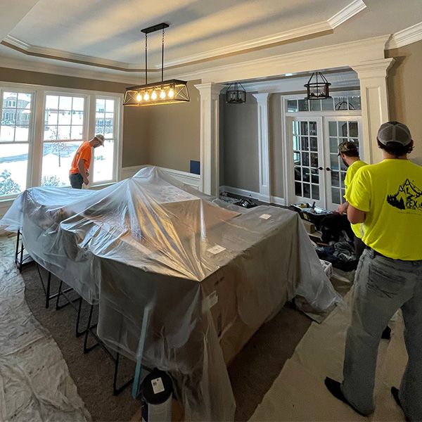 painters covering dining room table, painting walls