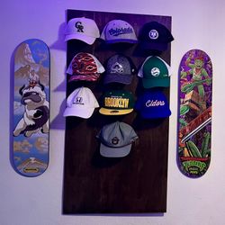 A real fan baseball cap collection displayed front-facing on a wall using The Original Squatchee™ adhesive hat hooks. Fan Hat Wall Display