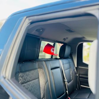 Baseball cap displayed inside the rear window of a truck using The Original Squatchee™ adhesive hat hooks. Truck Rear Window Baseball Cap Display