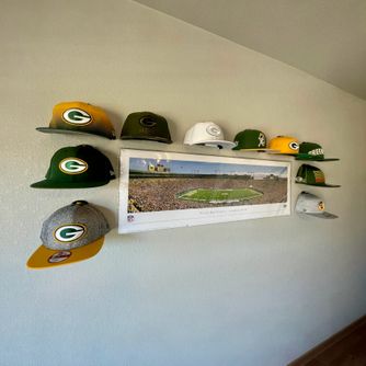 A real customer baseball cap collection displayed using The Original Squatchee™ adhesive hat hooks. Customer Hat Wall Display