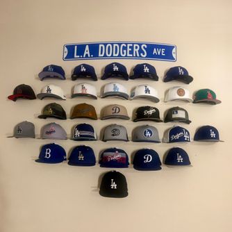 A real customer baseball cap collection displayed using The Original Squatchee™ adhesive hat hooks. Customer Hat Wall Display