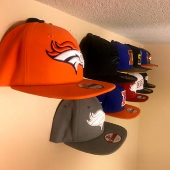 A real customer baseball cap collection displayed using The Original Squatchee™ adhesive hat hooks. Customer Hat Wall Display