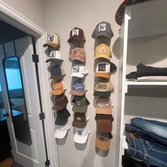 A real customer baseball cap collection displayed using The Original Squatchee™ adhesive hat hooks. Customer Hat Wall Display