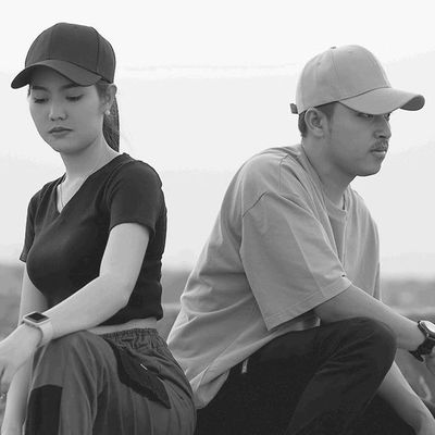 Man and Woman Showcasing Hats with Pride