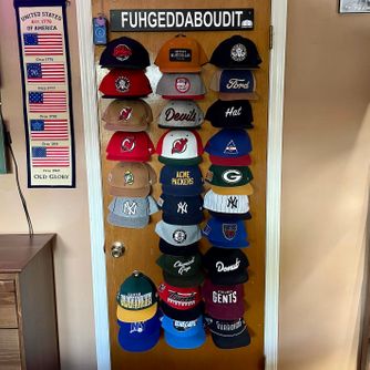 A real customer baseball cap collection displayed using The Original Squatchee™ adhesive hat hooks. Customer Hat Wall Display