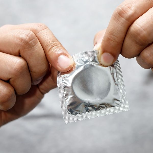 A man holding a condom.