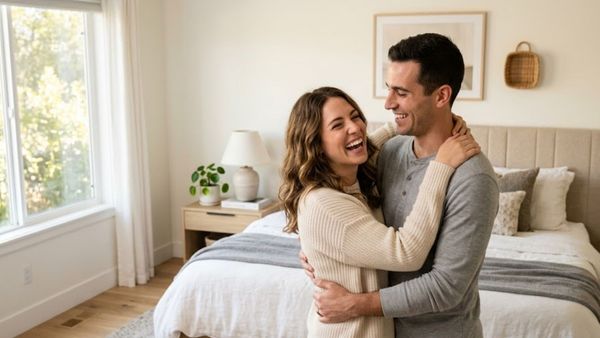 A happy couple embracing in a bright bedroom