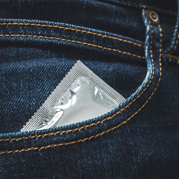 A condom foil peaking out of a denim pocket.