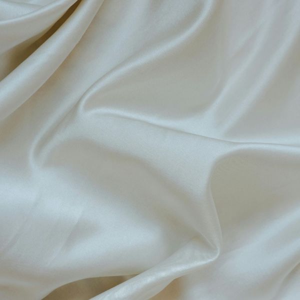 Silky white sheets, rumpled on a bed.