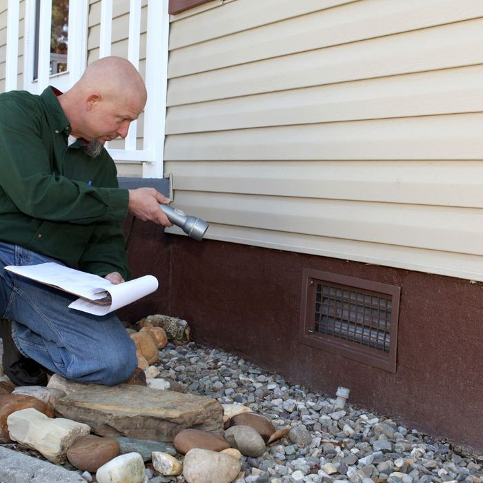 man inspecting home exterior