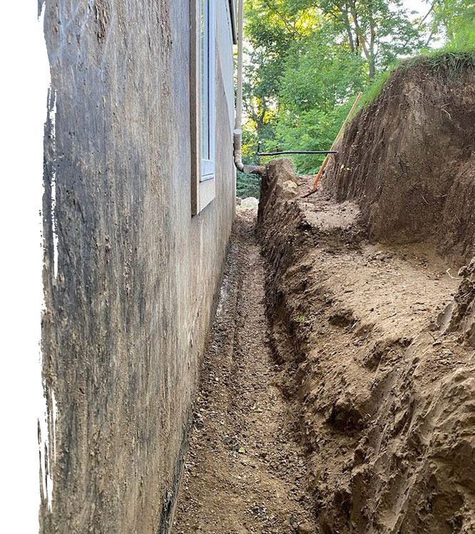 an in progress image of a dug trench for an exterior French drain