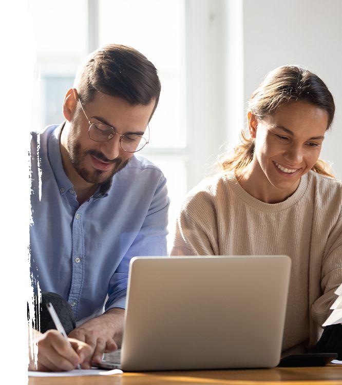 a couple looking at paperwork and a laptop together happily