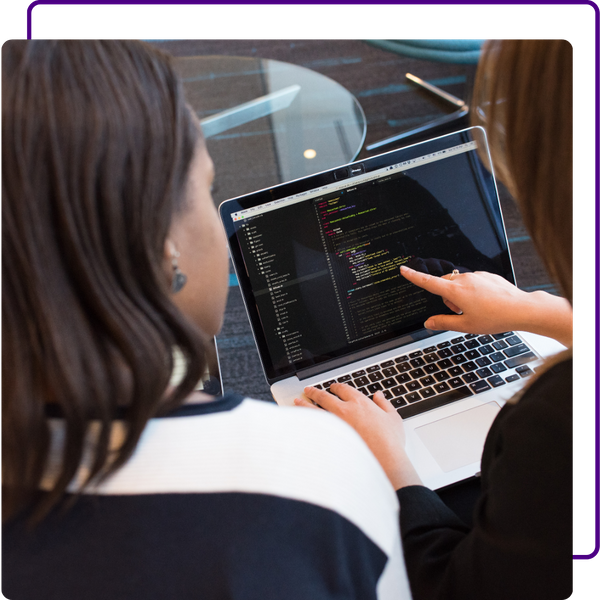 pointing at computer screen, examining code with coworker