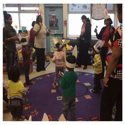 children and EarlyOn educators stand in circle on play mat to sing and dance to a song morningside location_4.jpg