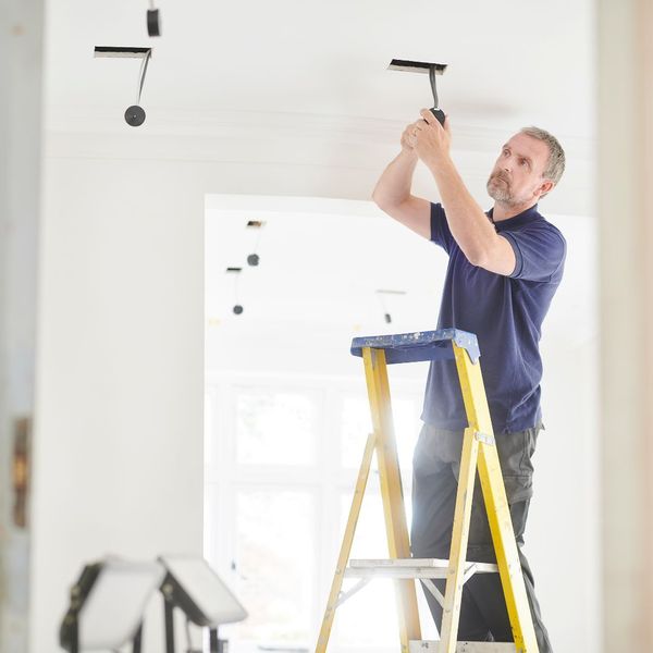 electrician installing ceiling fixtures
