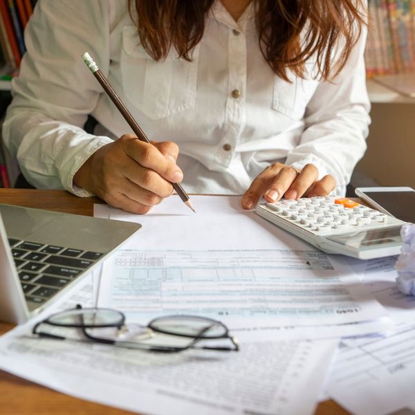 a business woman looking at paperwork with a calculator