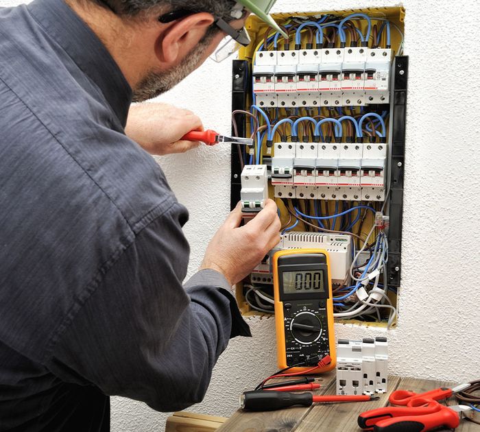 an electrician working on a circuit box