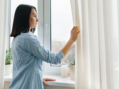 woman adjusting curtains