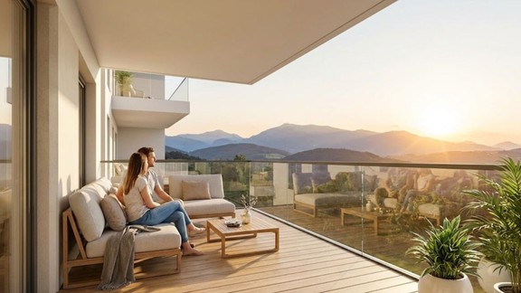 A couple sits on their scenic mountain view apartment balcony.