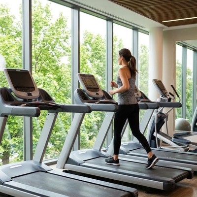 A woman exercises in a bright, modern, well-equipped gym.