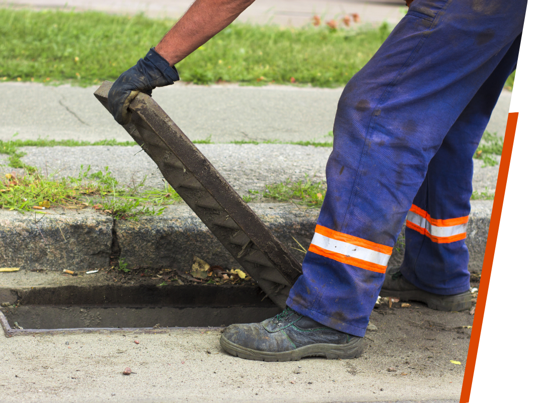 Worker hands opens a drain grate close up