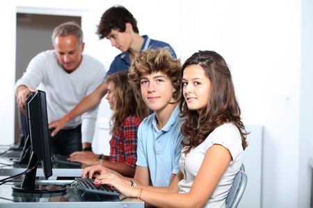 high schoolers using computers in a classroom