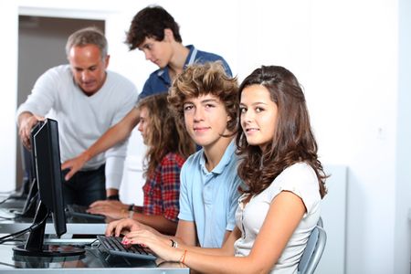 high schoolers using computers in a classroom