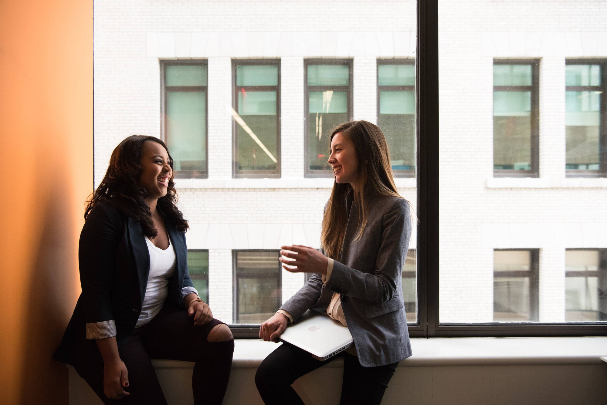 business people laughing by a window