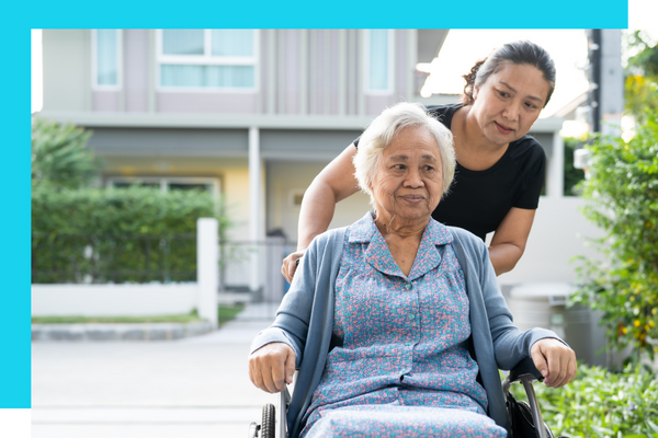 Woman pushing an old lady in a wheelchair