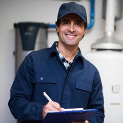 smiling HVAC technician holding a clipboard