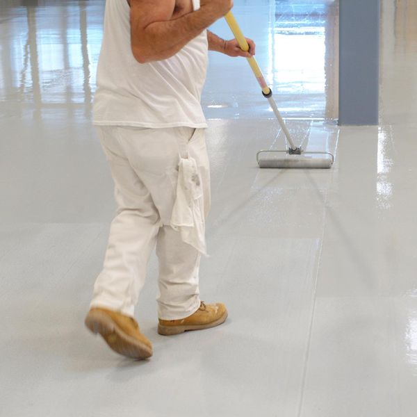 Worker applying epoxy floor coating