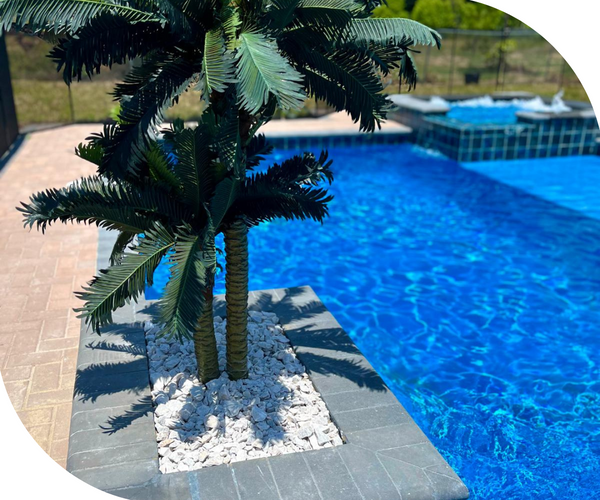 A pool next to an artificial palm tree